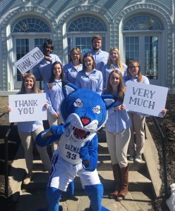 Willie the Wildcat and students holding thank you signs.