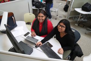 Two female students working on a computer in the RIC