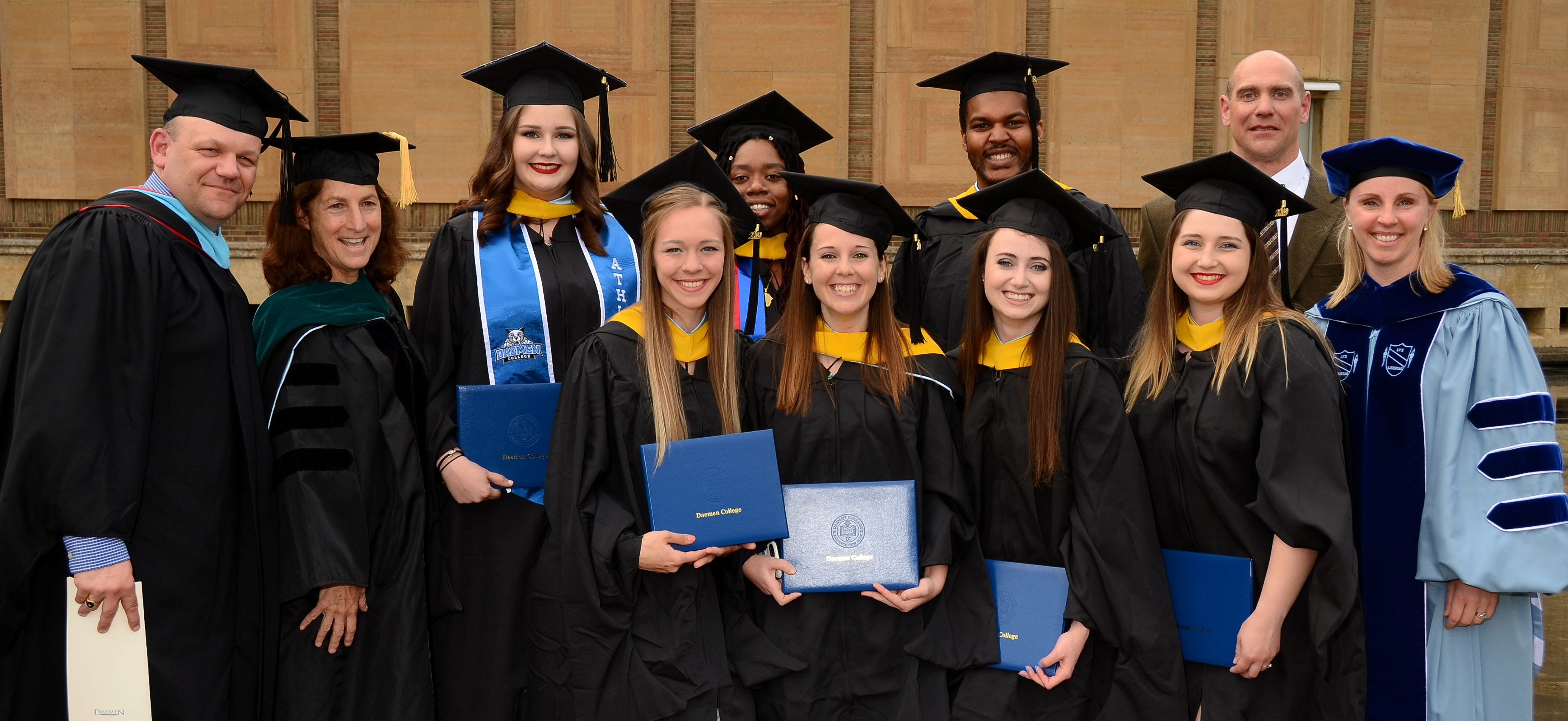 Athletic training students at graduation standing together outside of Kleinhan's Music Hall