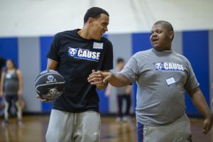 CAUSE participant playing basketball with Daemen men's basketball player. 