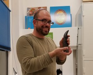 Dr. Domenic D’Amore is shown with a Tyrannosaurus Rex tooth.