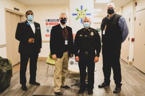 Four men in masks standing in a hallway
