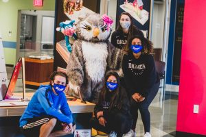 Daemen students in masks with puppet willie the wildcat in the buffalo library