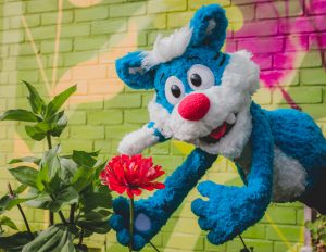 Willie the Wildcat Puppet holding a flower