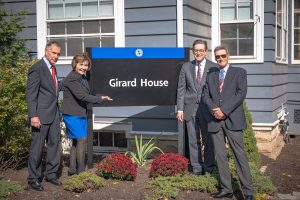 Former Daemen President Martin Anisman, Sue Girard, President Gary Olson and Jay Girad standing in front of sigh for Girard House
