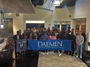 Dare2Dream participants holding a Daemen banner