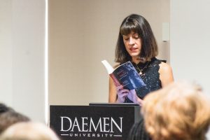 Susan Furber reading from her book behind a Daemen podium