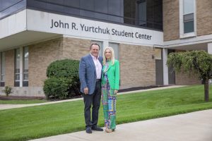 John R. Yurtchuk and his wife standing in front of renamed student center