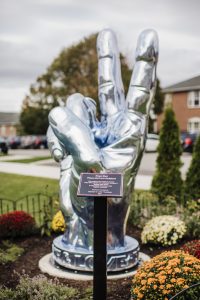A chrome peace sign is dedicated in a peace garden at Daemen University.