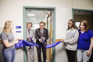 President Olson cuts the ribbon on the veterans success center with two veteran students