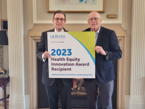 From left to right. Gary A. Olsen, Daemen University president and Art Wingerter, Univera Healthcare president holding a sign that says 2023 Health Equity Innovation Award Recipient, addressing racial and ethnic health disparities.