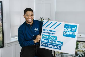 Student with Day of Giving poster