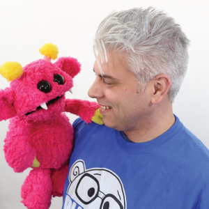 Adam Kreutinger holding pink puppet