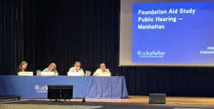 Parshall sitting at panel table on stage at Rockefeller Institute