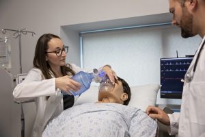 Student using a respirator on a medical mannequin