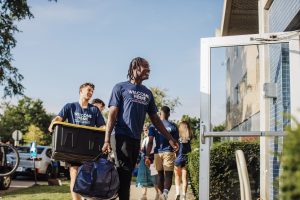 Move in crew helping carry boxes into canavan hall