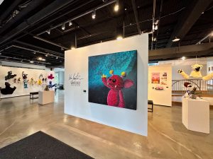 Painting of Pink alien puppet hanging in Peter and Elizabeth C. Tower Gallery in the Nancy Haberman Gacioch Center for Visual and Performing Arts