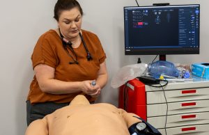 Faculty member demonstrating on a medical mannequin 