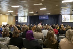 President Gary A. Olson stands in front of a seated audience as he delivers the State of the University