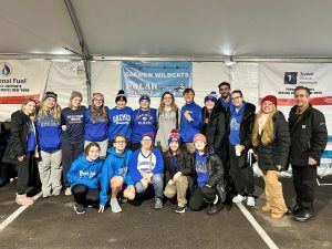 Group of Daemen students dressed in Daemen gear inside a tent at the Polar Plunge