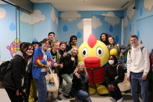 Group of students in Japan posing with Tokyo weather mascot