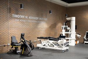 Brown brick wall with lettering on it and physical therapy equipment in front of it
