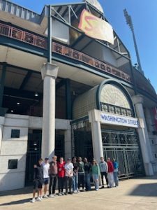 Group of college students standing outside the entrance to a minor league baseball stadium