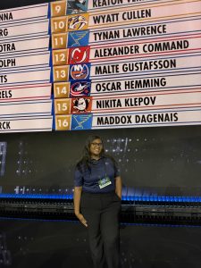 Female college student standing in front of the NHL draft board