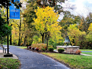 Fall photo of Founders Bell with colorful trees in the background