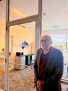 A man standing in front of the glass walls of a lounge