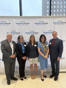 Michael Brogan, Lisa Rafalson, Robin King, Elizabeth Wright, and Greg Ford stand together in front of a Highmark step and repeat backdrop